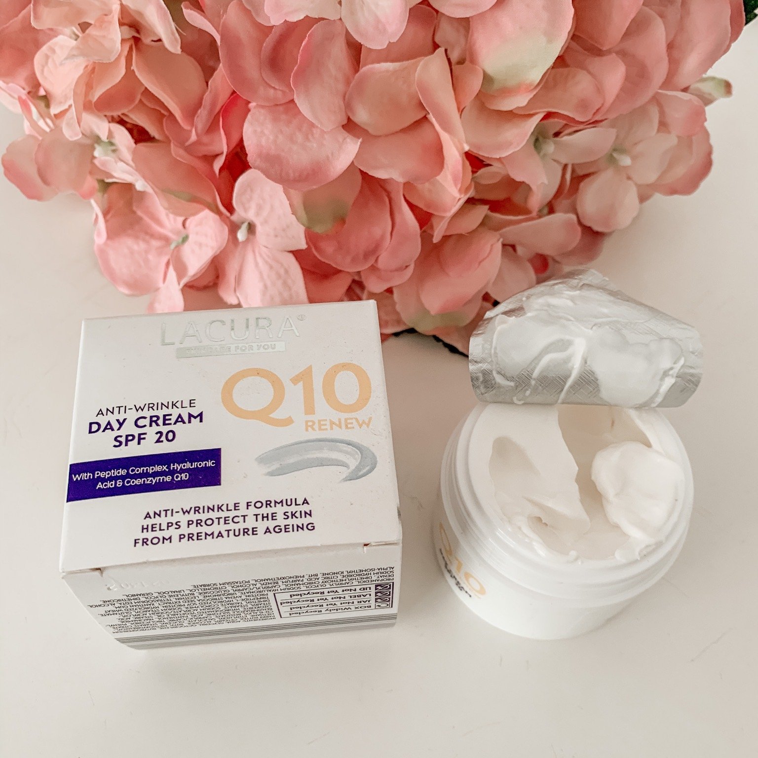 a tub of Lacura day cream with the lid of showing the creamy texture of the product