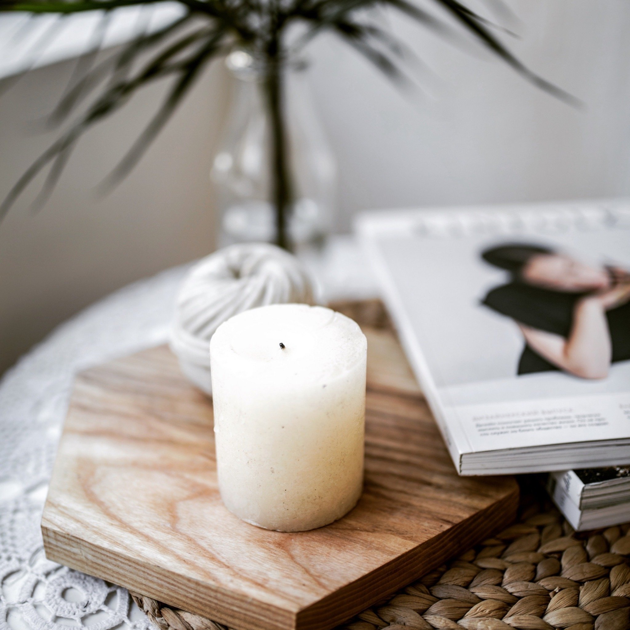 a cosy side table with a white candle making an autumn vibe