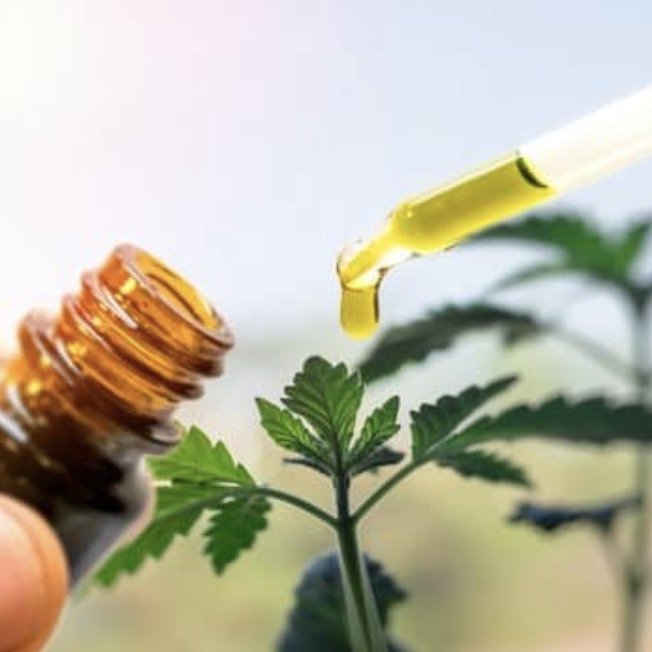 a small bottle of hemp oil with the pipette pulled out sucking up some of the oil