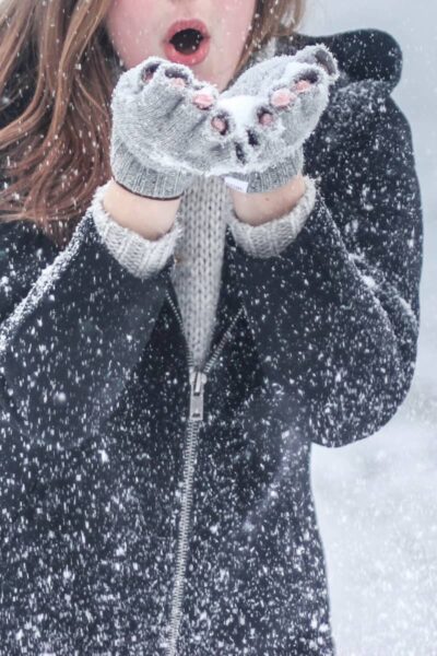 a lady with cold hands wearing mittens